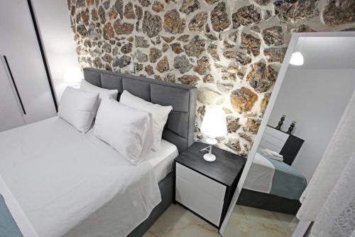 リトホロにあるElysian Stone Apartment IIのベッドと石の壁のある寝室