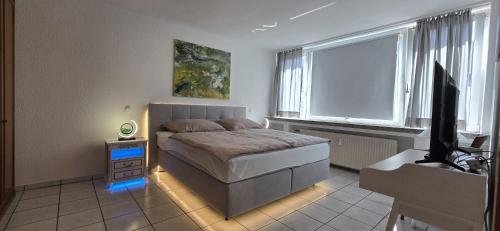 a bedroom with a bed and a flat screen tv at Vacation and business city apartment in Mönchengladbach