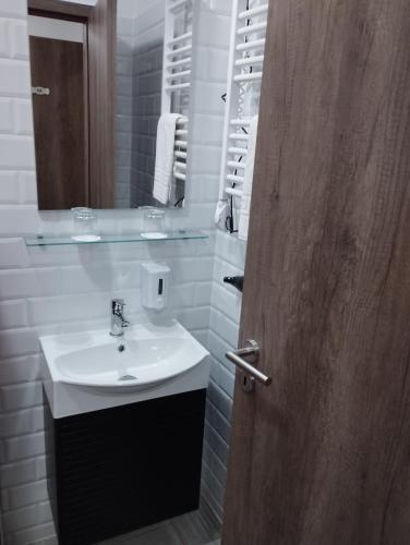a bathroom with a sink and a mirror and a door at Régi Posta Hotel és Étterem in Debrecen
