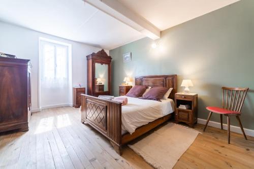 una camera da letto con un grande letto e una sedia rossa di La Maison d'Adèle a Vertou
