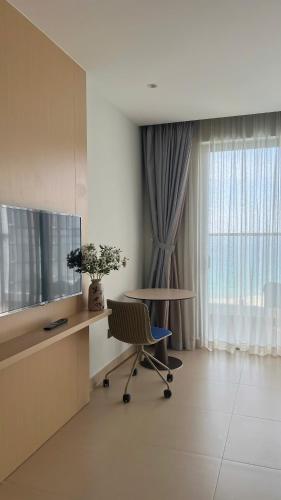 a room with a desk with a television and a chair at Seaview Stella The Arena in Cam Ranh International Airport