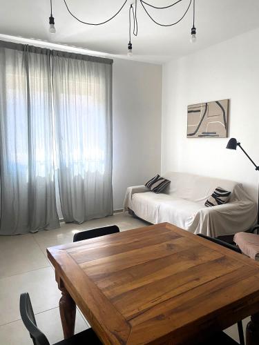 a living room with a table and a bed at MAISON ANZIO E ROSA in Ravenna