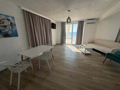 a living room with a couch and a table and chairs at David apartments and rooms in Dobra Voda