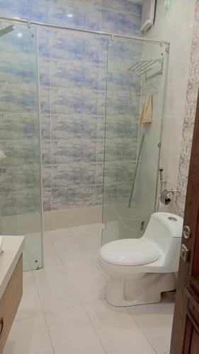 a bathroom with a toilet and a glass shower at Peaceful Hilltop Apartment in Changla Gali in Chhāngla Gali