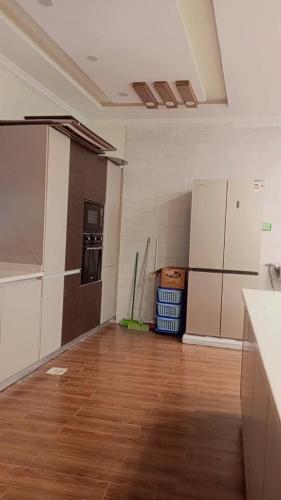 an empty room with a kitchen with wooden floors and appliances at Peaceful Hilltop Apartment in Changla Gali in Chhāngla Gali