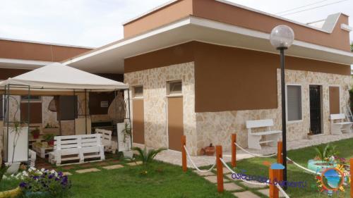 a small house with a porch and a yard at Ostello Salento in Alezio