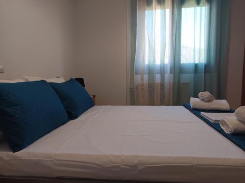 a large bed with blue pillows in a bedroom at Villa Eleni in Kypséli