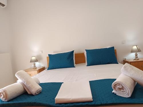 a bedroom with a large bed with blue pillows at Villa Eleni in Kypséli