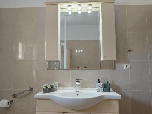 a bathroom with a white sink and a mirror at Villa Eleni in Kypséli