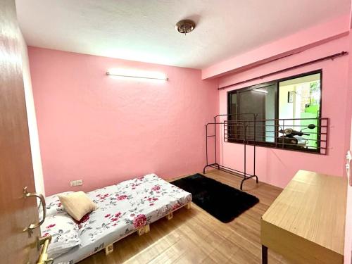 a bedroom with a bed in a room with pink walls at Happy Stay in Kathmandu