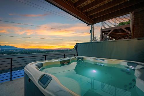 a hot tub on a balcony with the sunset at All-New Luxe Stay Views, Sauna & Hot Tub villa in Holladay