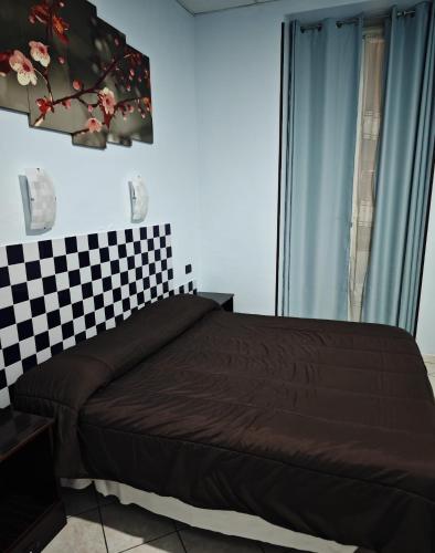 a bedroom with a bed with a checkered wall at Hotel Esperia in Sanremo