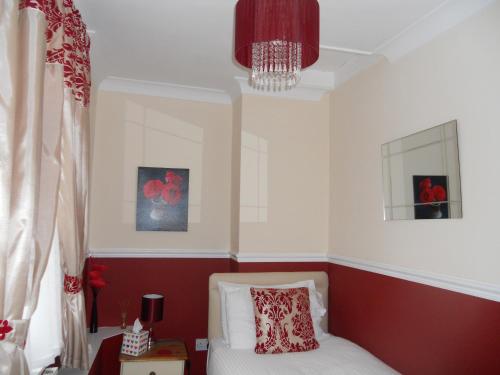 a bedroom with a bed and a chandelier at All Seasons Guest House in Great Yarmouth