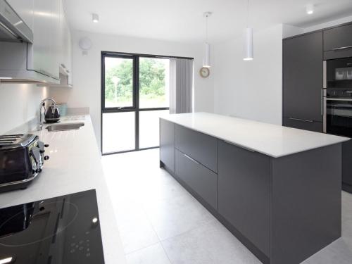 a kitchen with black cabinets and white counter tops at Caledonia View in Aviemore
