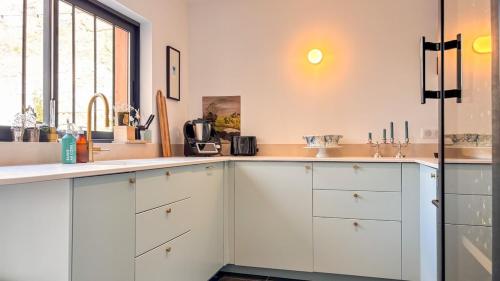a kitchen with white cabinets and a sink at Large house, very high standing in Bordeaux
