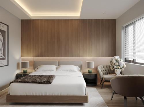 a bedroom with a large bed and a chair at Nature Hotel - Lac Long Quan in Hanoi