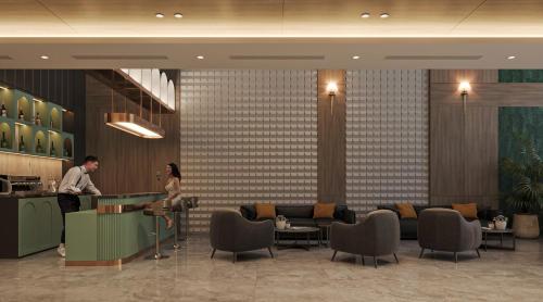 a man and a woman standing at a counter in a lobby at Nature Hotel - Lac Long Quan in Hanoi