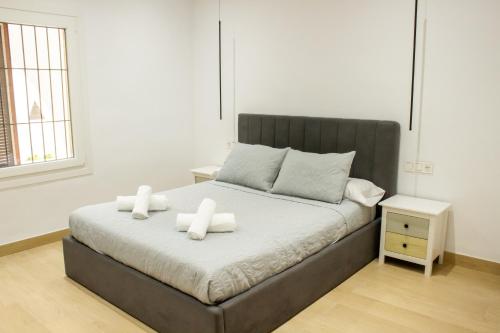 a bedroom with a bed with two white candles on it at Gaviotas Playa in Almerimar