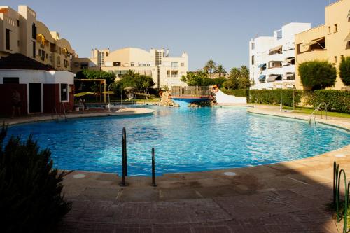 a large swimming pool in a city with buildings at Gaviotas Playa in Almerimar