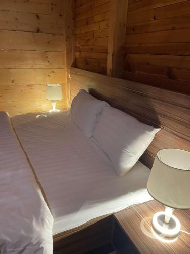 a bed with white sheets and pillows in a room at اكواخ وشاليهات جولدن الفندقية in Jeddah