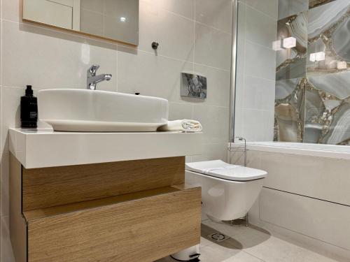 a white bathroom with a sink and a toilet at Magnolia Apartment Luxury and Relaxation on the Sava in Belgrade