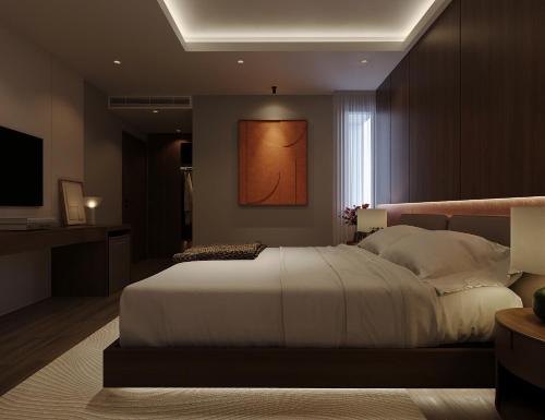 a bedroom with a large white bed and a television at Nature Hotel - Lac Long Quan in Hanoi