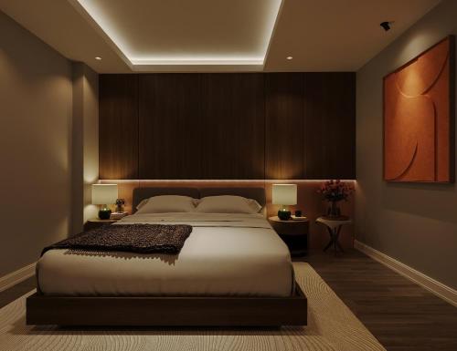 a bedroom with a large bed and two tables with lamps at Nature Hotel - Lac Long Quan in Hanoi
