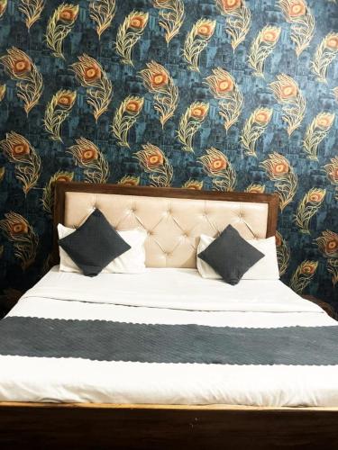 a bedroom with a bed with a floral wallpaper at EZ Stayz By Vilaasitaa Agra in Agra