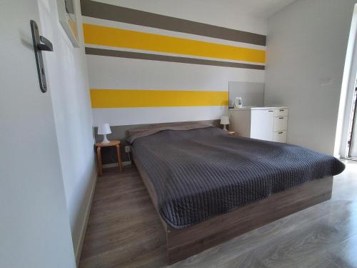 a bedroom with a bed with a striped wall at Ludna 27 in Niechorze