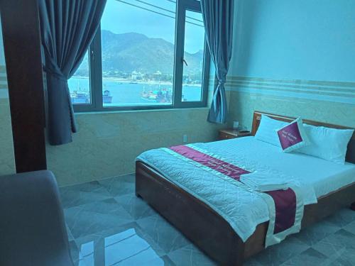 a bedroom with a bed and a large window at Mimosa 8 Hotel - Ninh Chử in Ninh Hải