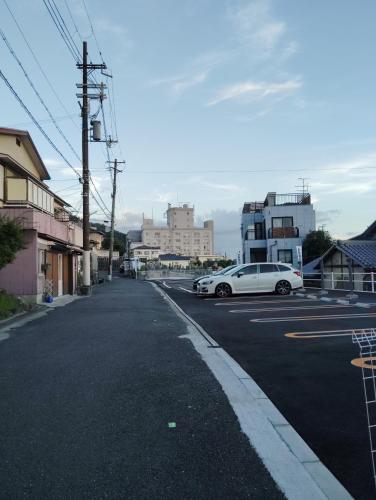a white car parked on the side of a street at ムラキン民泊 in Higashi-osaka