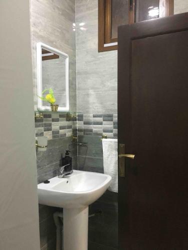 a bathroom with a sink and a mirror at Passo Nador 3 chambres in Nador