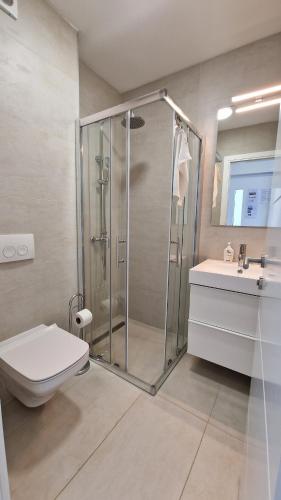 a bathroom with a shower and a toilet and a sink at Villa Miri R2 in Privlaka