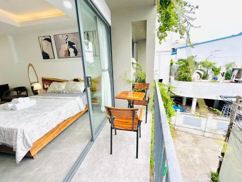 a bedroom with a bed and a table and chairs at 307MSNK Luxe Studio l Balcony & Kitchen in Can Tho