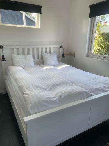 un grande letto bianco in una stanza con una finestra di Kungsgatan 36 a Borgholm