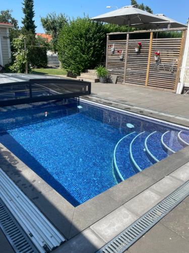 piscina con acqua blu e ombrellone di Kungsgatan 36 a Borgholm