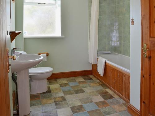 a bathroom with a sink and a toilet and a tub at Fenham Barn in Soulby