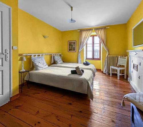 a bedroom with a large bed with yellow walls at Cocon Familial Surf & Menhirs Idéal Golfe Morbihan in Plouharnel