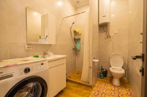 a bathroom with a washing machine and a toilet at Атлантис Резорт in Chon-Sary-Oy