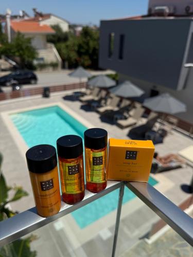 three bottles of spices sitting on a shelf next to a pool at Diamond Deluxe Loft in Iraklitsa