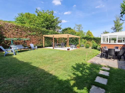 a backyard with a gazebo and chairs at The Nest in Aylsham