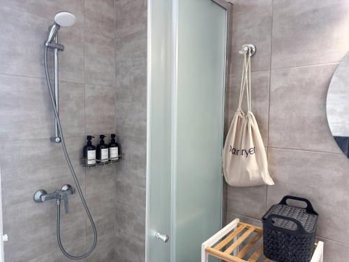 a bathroom with a shower with a bag on the wall at Modern Msida 2 BDR Penthouse with Rooftop, AC & WIFI in Tal-Ħriereb