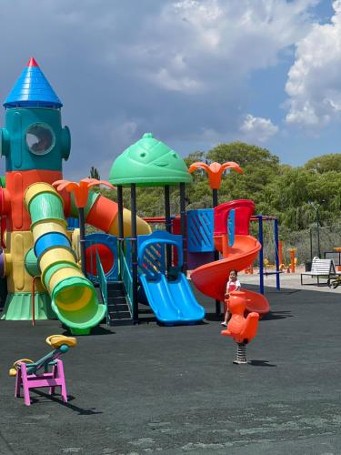 a child standing in front of a playground at Атлантис Резорт in Chon-Sary-Oy