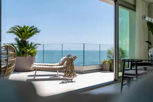 a room with a balcony with a view of the ocean at Opera Suite Hotel Pesaro in Pesaro