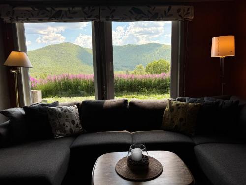 a living room with a couch and a large window at Bjørkli Lodge in Geilo