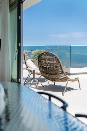 a table and chairs on a balcony with a view of the ocean at Opera Suite Hotel Pesaro in Pesaro