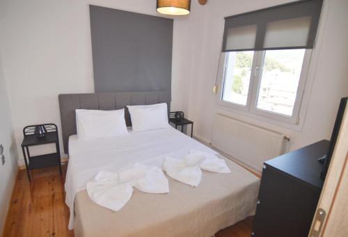 a bedroom with a bed with two white towels on it at Serene Apartment in Kastoria