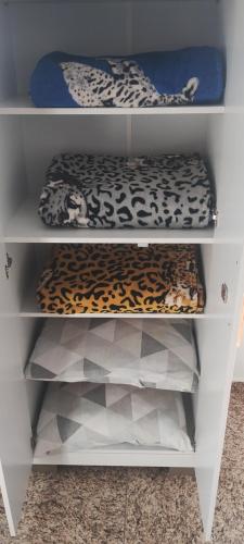 une étagère blanche avec des léopards dans l'établissement Kitnet montanha mágica, à São Thomé das Letras