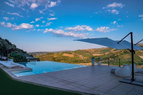 a swimming pool with an umbrella and a view at Villa Greco in Rossano