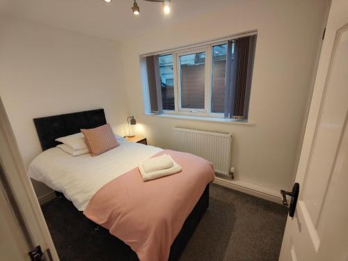 a small bedroom with two beds and a window at Lovely refurbished apartments, Morecambe Promenade in Morecambe